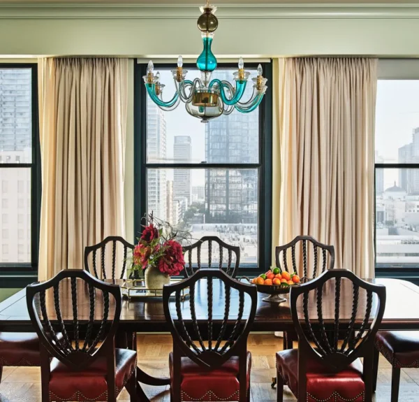 An elegant wooden table in a dining room with glass chandelier