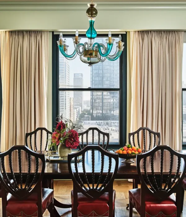 An elegant wooden table in a dining room with glass chandelier