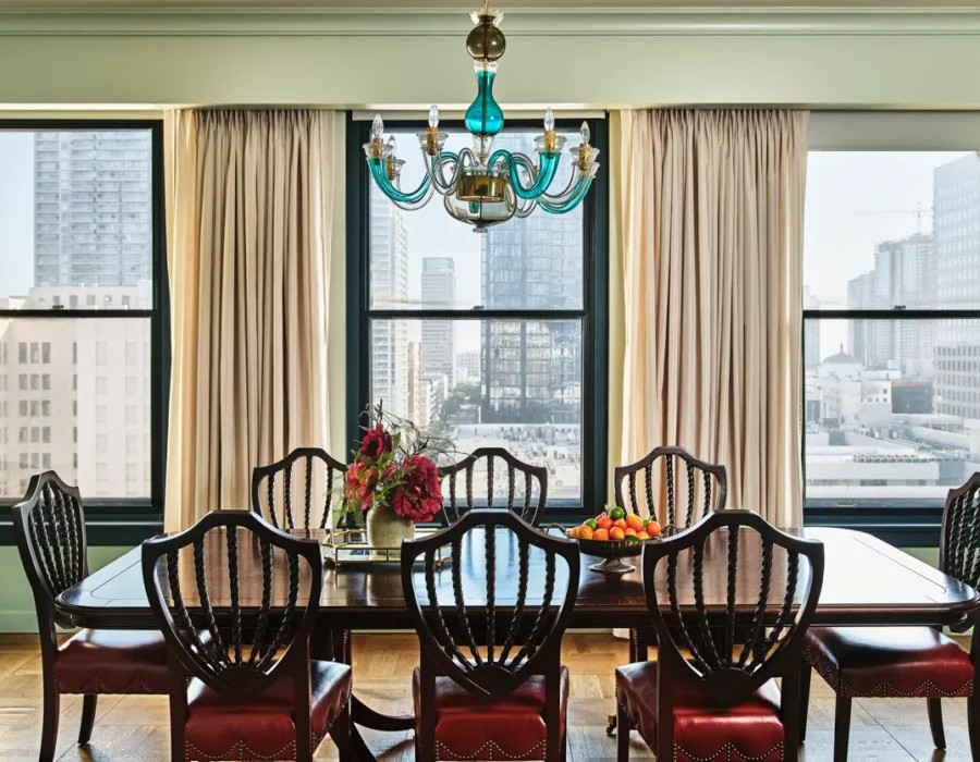 An elegant wooden table in a dining room with glass chandelier