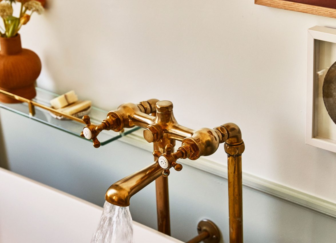 Water flows from a vintage brass faucet into a white bathtub in a luxury Los Angeles hotel suite.