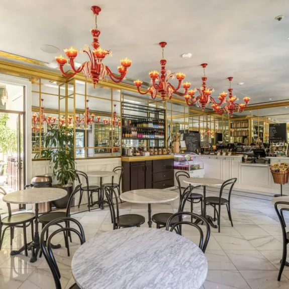 Elegant red chandeliers and marble tables create a chic atmosphere at Cafe Ora in downtown Los Angeles.
