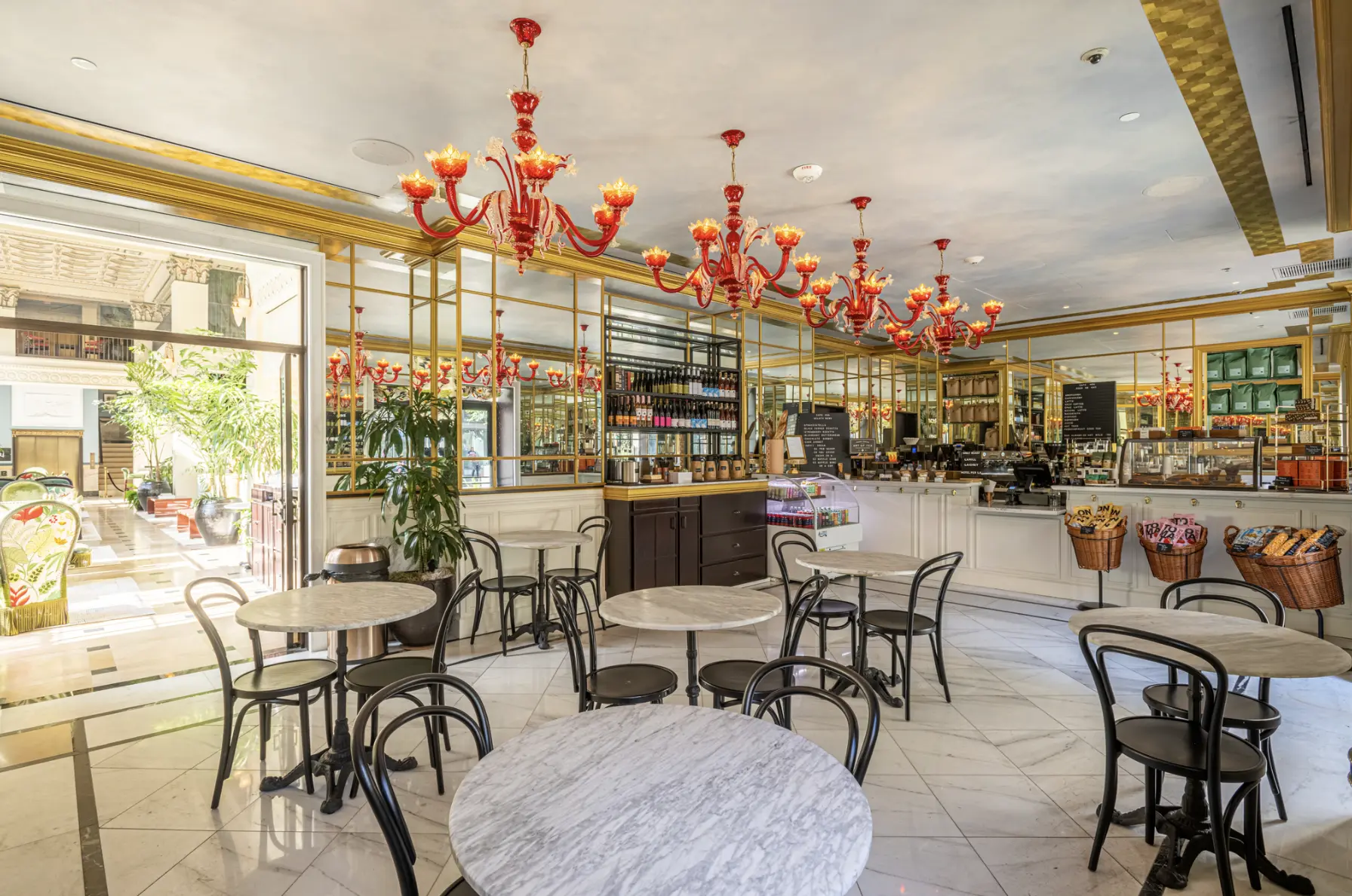Elegant red chandeliers and marble tables create a chic atmosphere at Cafe Ora in downtown Los Angeles.
