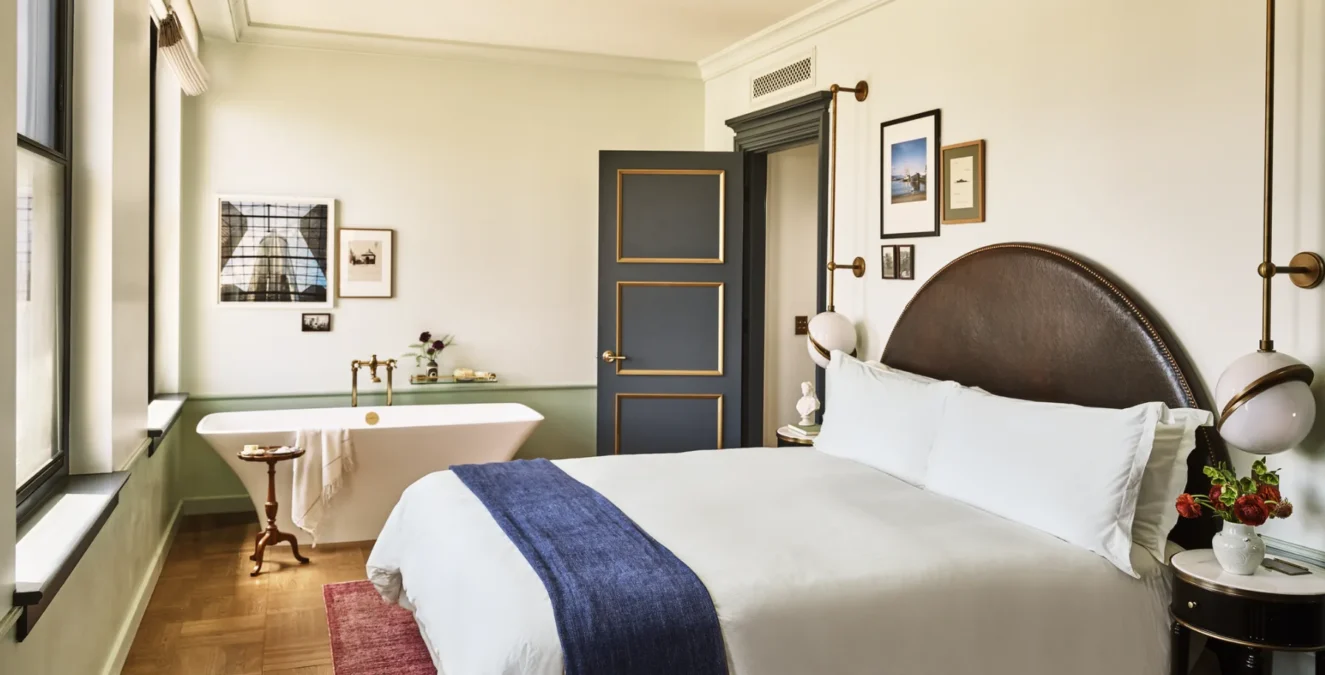 A hotel room with large bed and a soaking tub in the corner