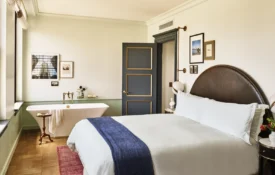 A hotel room with large bed and a soaking tub in the corner