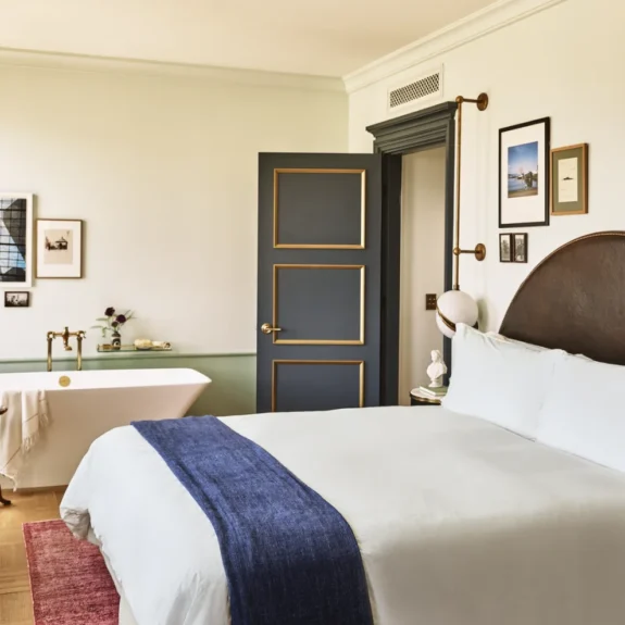 A hotel room with large bed and a soaking tub in the corner