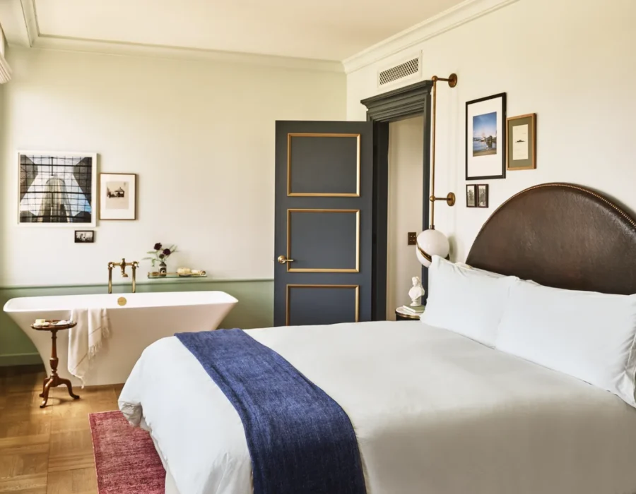 A hotel room with large bed and a soaking tub in the corner