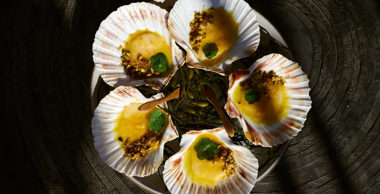 Freshly plated scallops in decorative shells at Ristorante Per L'Ora, an Italian restaurant in Los Angeles.