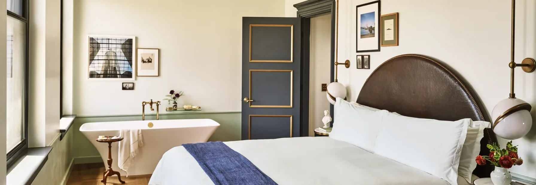 Experience luxury at Hotel Per La in a stylish room featuring a plush bed and a vintage-inspired soaking tub.