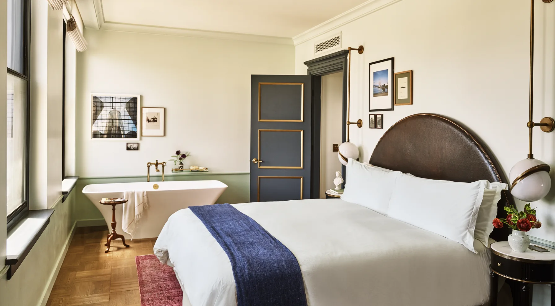 Experience luxury at Hotel Per La in a stylish room featuring a plush bed and a vintage-inspired soaking tub.