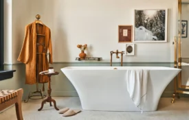 A white freestanding tub and waffle-knit robe in a bright suite at Hotel Per La in downtown Los Angeles.
