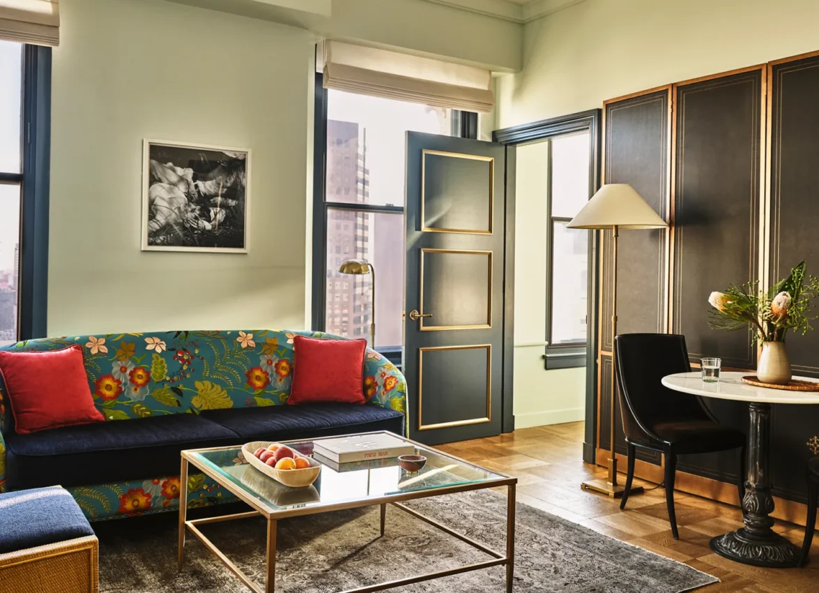 This stylish living area within a boutique hotel suite in Los Angeles features a floral sofa and chic decor.