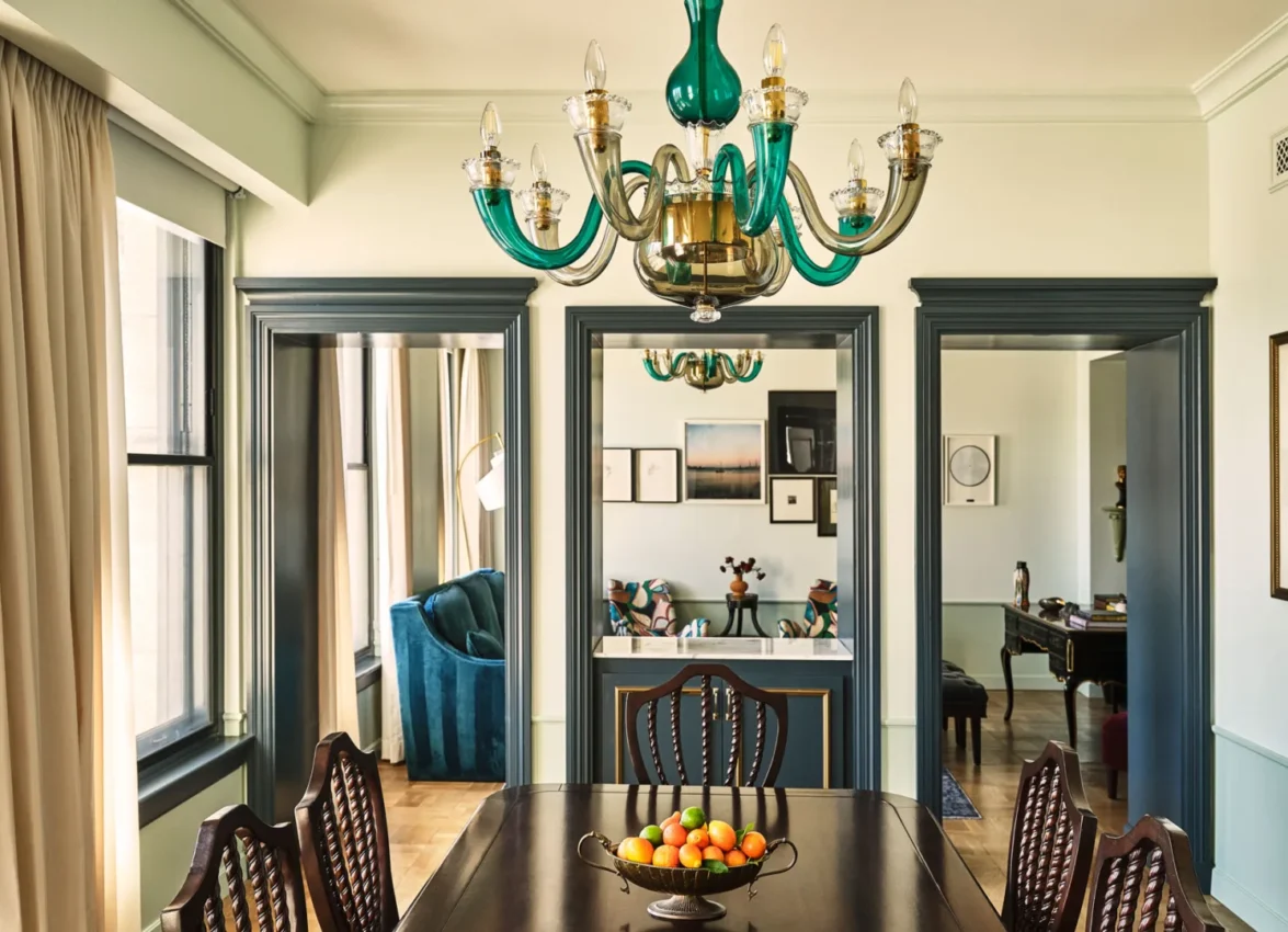 A refined dining area in a Hotel Per La suite overlooks the downtown Los Angeles city skyline.