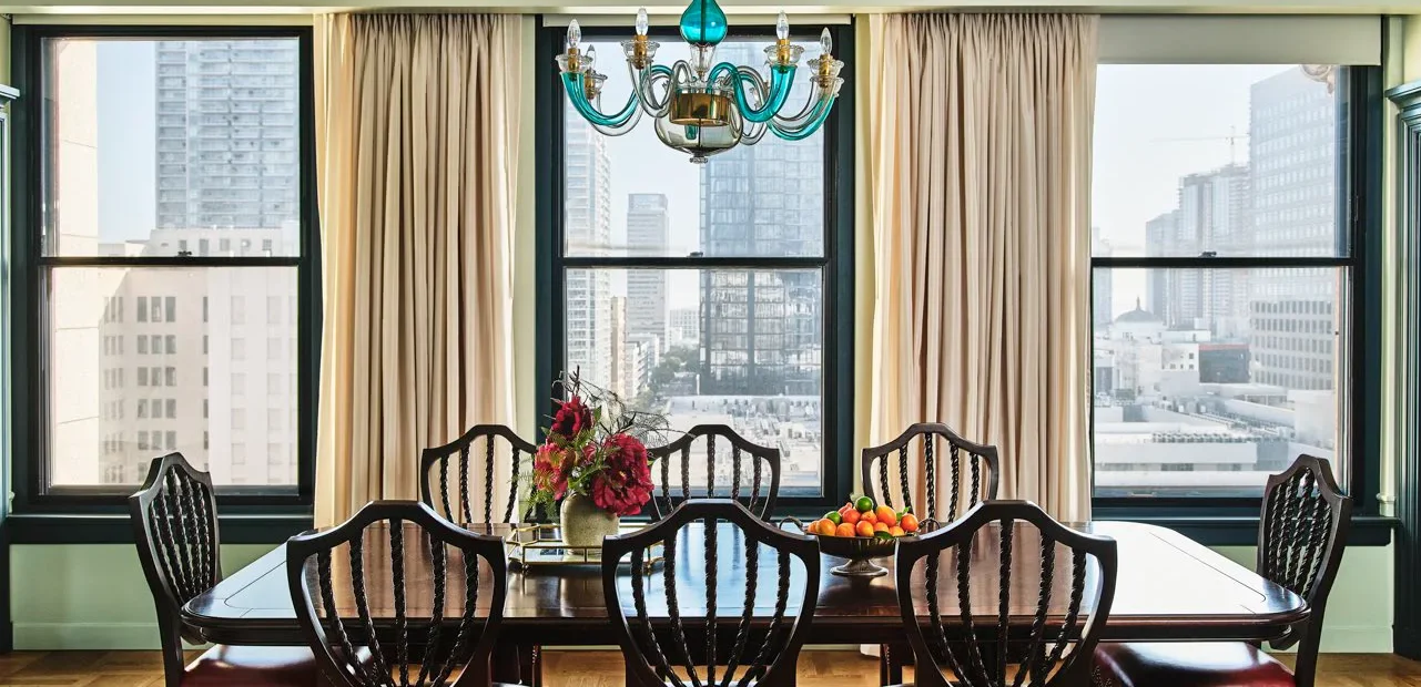 An elegant wooden table in a dining room with glass chandelier