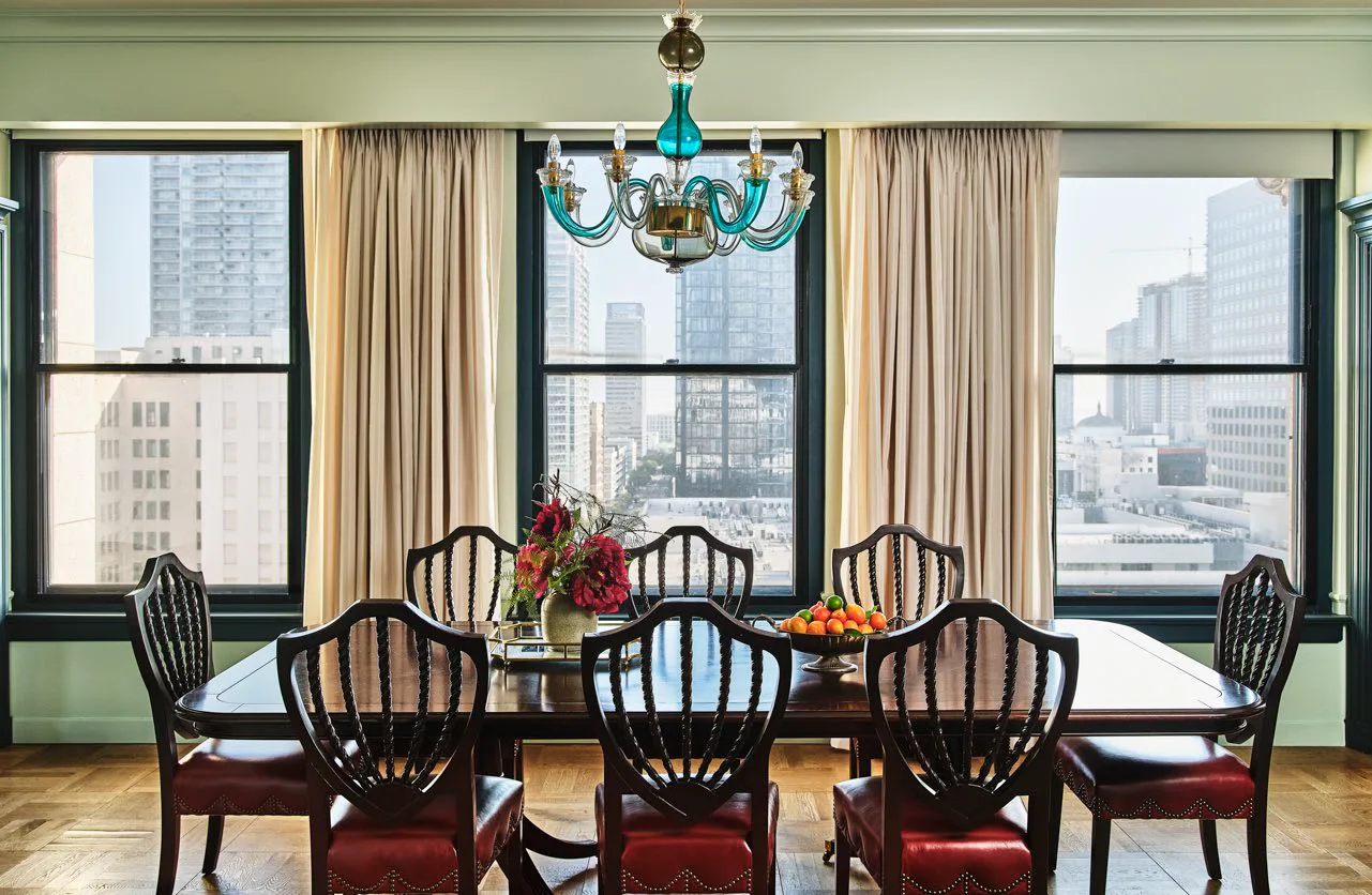 An elegant wooden table in a dining room with glass chandelier