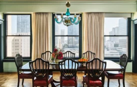A luxury dining table with a turquoise chandelier and city views inside one of our hotel suites in Los Angeles.