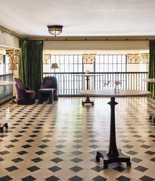 A mezzanine event space features checkered flooring, tall cocktail tables, and rich velvet drapes in Los Angeles.