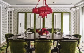 Green velvet chairs surround a long dining table at Ristorante Per L'Ora, an elegant event venue in Los Angeles.