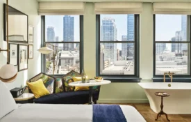 A hotel room with large bed and a soaking tub in the corner