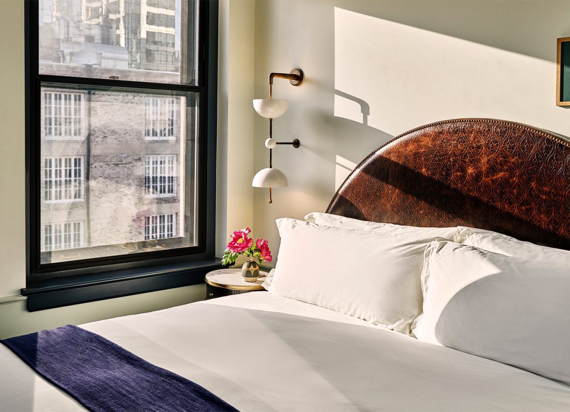 A large bed in a hotel suite with view of downtown LA