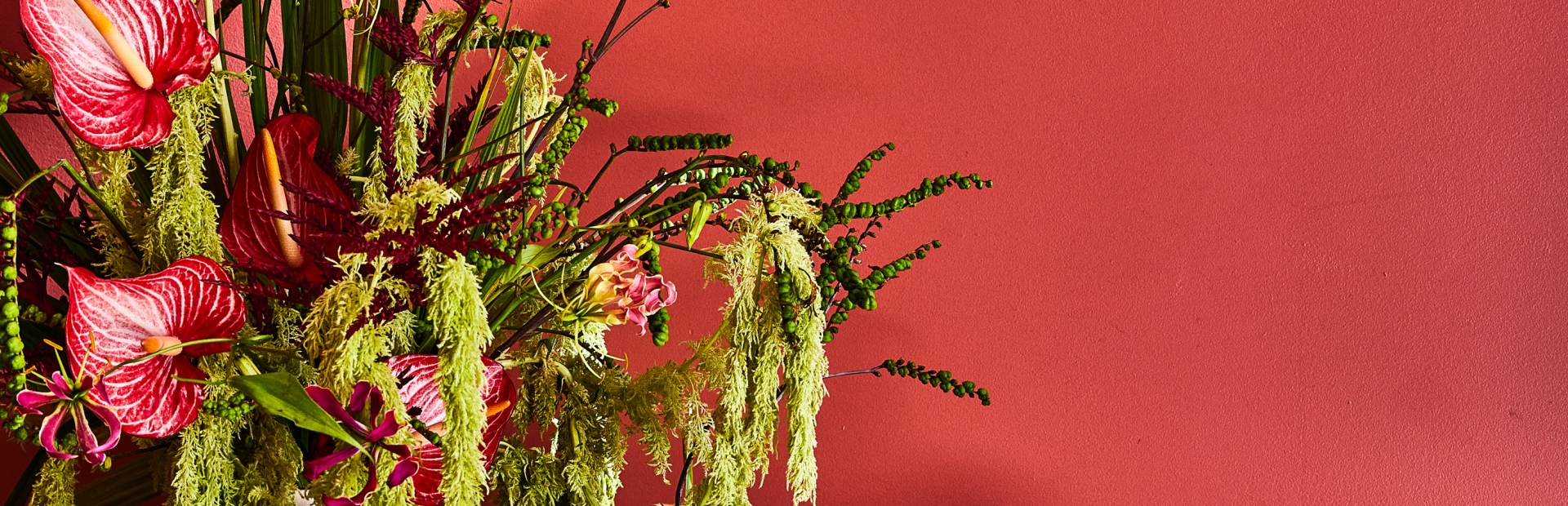 cocktails placed on a table beside a vase with flowers.