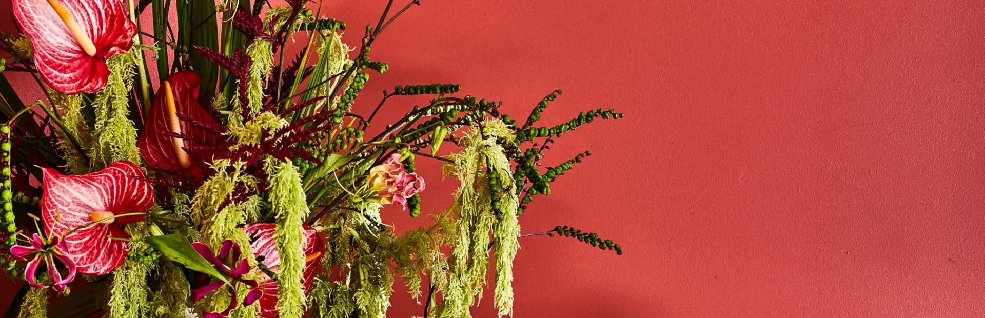 cocktails placed on a table beside a vase with flowers.