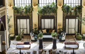 Ornate architectural details and lush greenery frame an elegant seating area in this boutique hotel in Los Angeles.