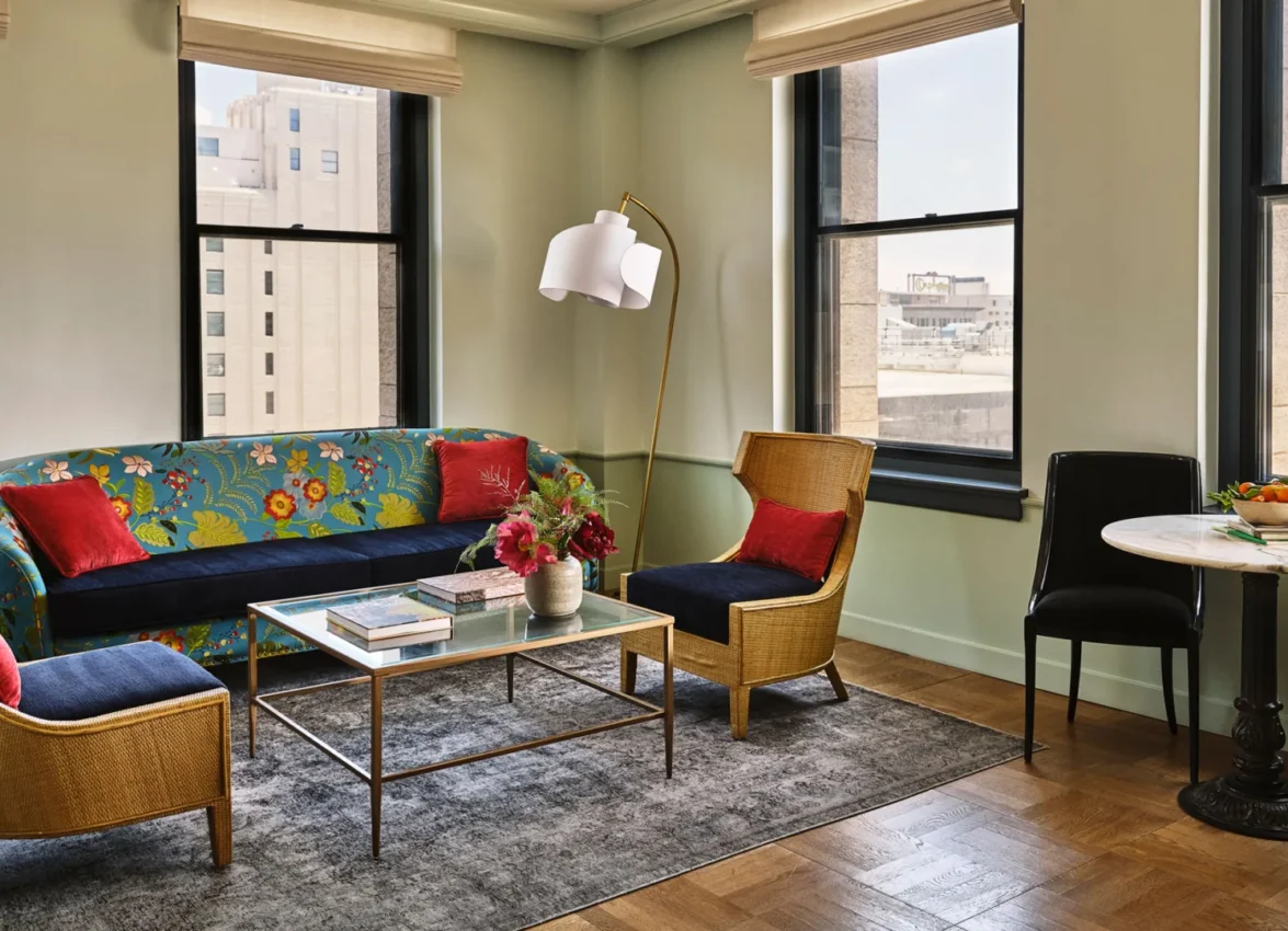 A floral sofa and woven chairs overlook the city in a boutique hotel suite at Hotel Per La.