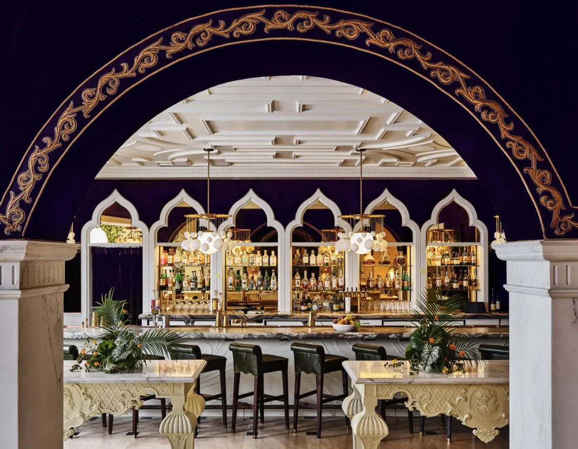 A luxurious bar with purple velvet walls and gold trim at Ristorante Per L'Ora in downtown Los Angeles.