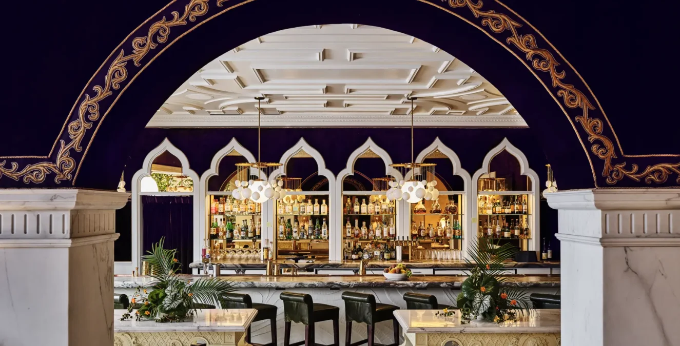 A luxurious bar with purple velvet walls and gold trim at Ristorante Per L'Ora in downtown Los Angeles.