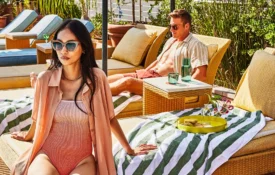A couple relaxes on wicker lounge chairs beside the rooftop pool at Bar Clara in downtown Los Angeles.