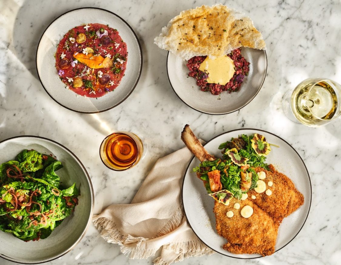 A gourmet spread of Italian cuisine on a marble tabletop at Ristorante Per L'Ora in downtown Los Angeles.