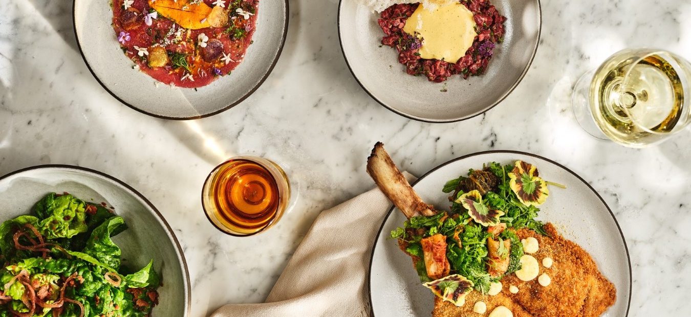 A gourmet spread of Italian cuisine on a marble tabletop at Ristorante Per L'Ora in downtown Los Angeles.