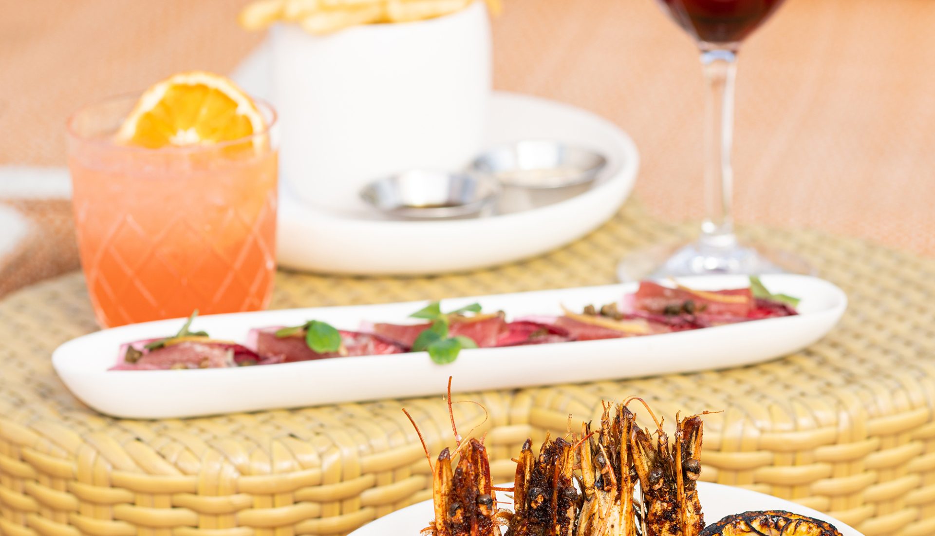 Grilled shrimp skewers and refreshing cocktails served at Bar Clara, a premier rooftop bar in Los Angeles, CA.