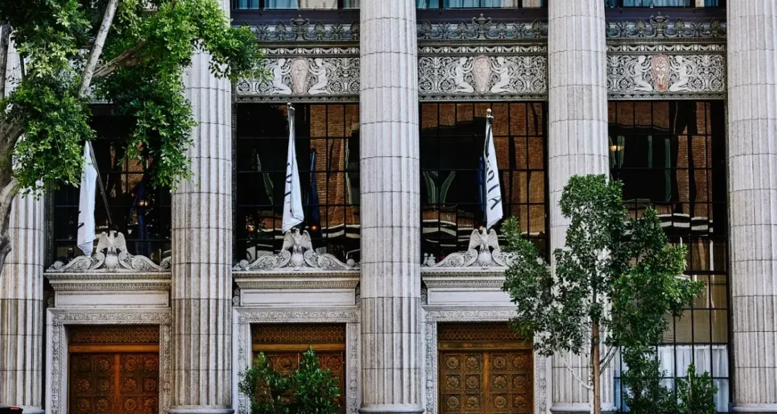 a blue car parked in front of a tall building