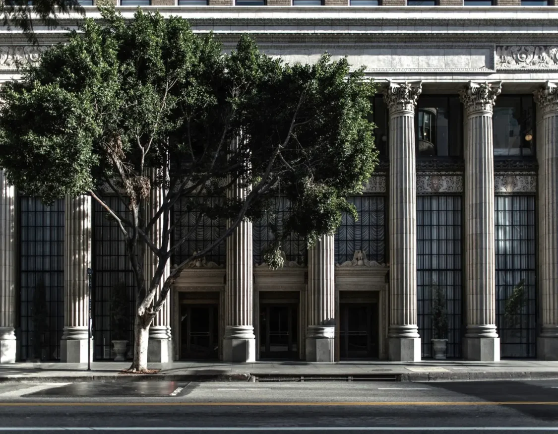 a large building with columns and a tree in front of it