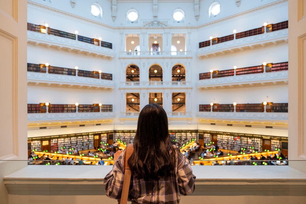 A guest overlooks the grand, multi-level white atrium of a historic venue, ideal for weddings in Los Angeles.
