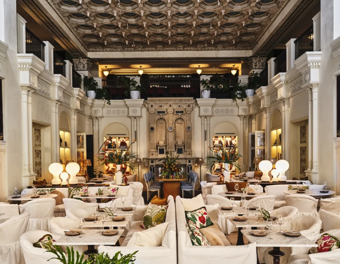 Plush white seating and marble tables fill the grand, ornate dining room at Ristorante Per L'Ora in downtown LA.