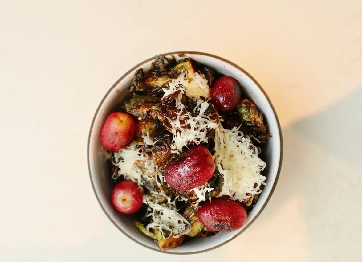 Charred Brussels sprouts topped with grapes and shaved cheese at Ristorante Per L'Ora, a top Downtown LA restaurant.