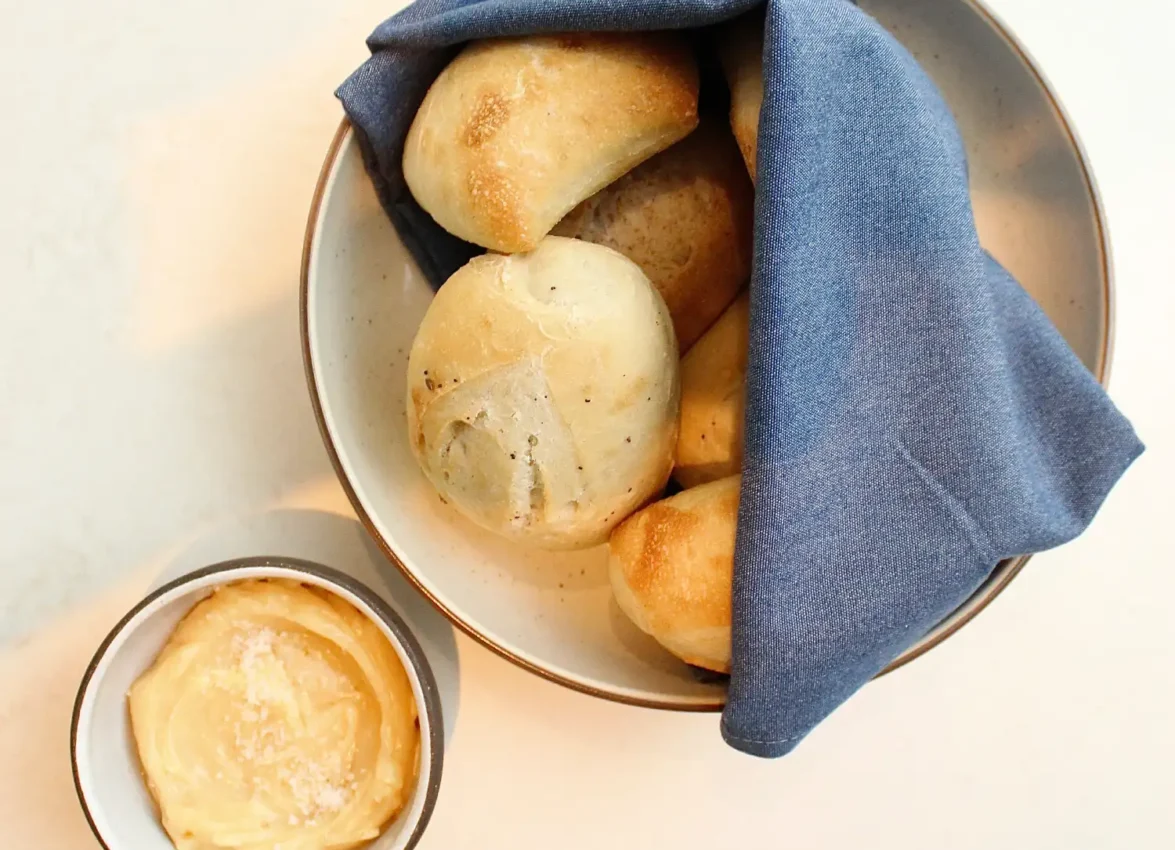 Warm artisan dinner rolls served with creamy salted butter at Ristorante Per L'Ora in downtown Los Angeles.