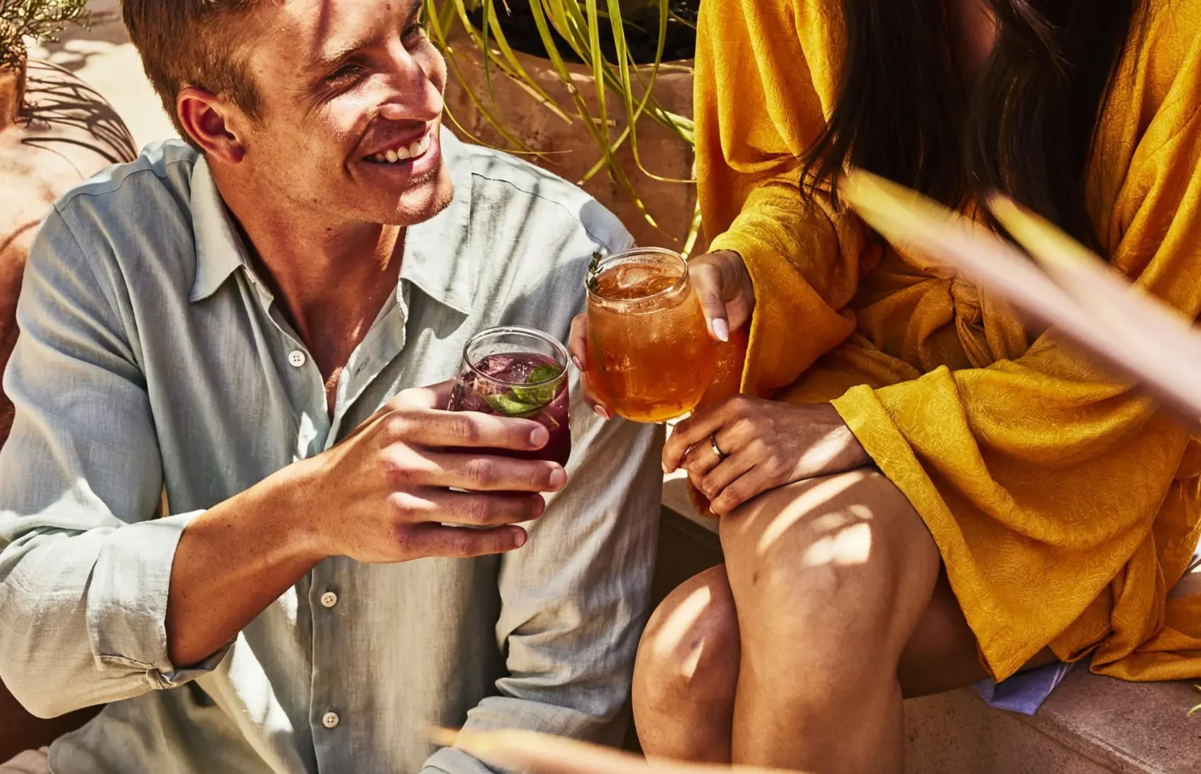 A couple toasts with craft cocktails while relaxing on the sun-drenched patio of Bar Clara in downtown Los Angeles.