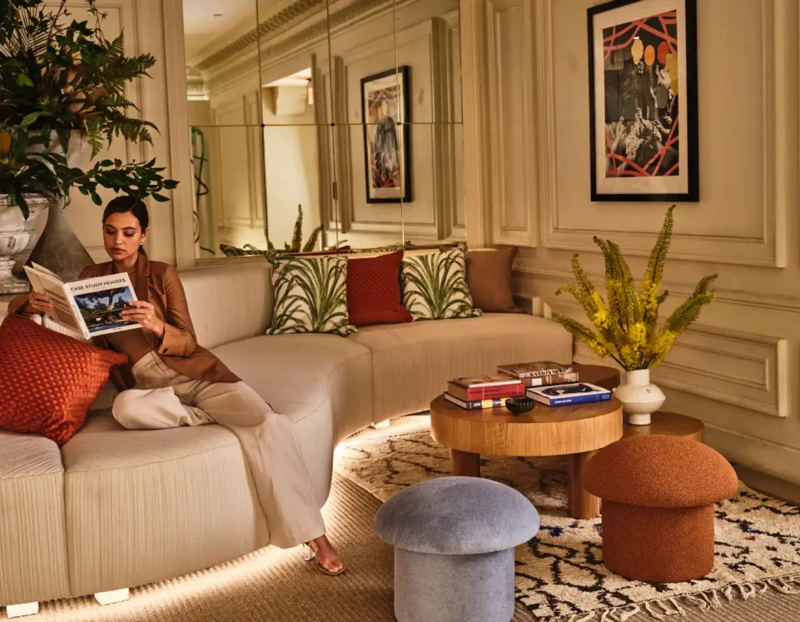 a woman sitting on a couch reading a magazine