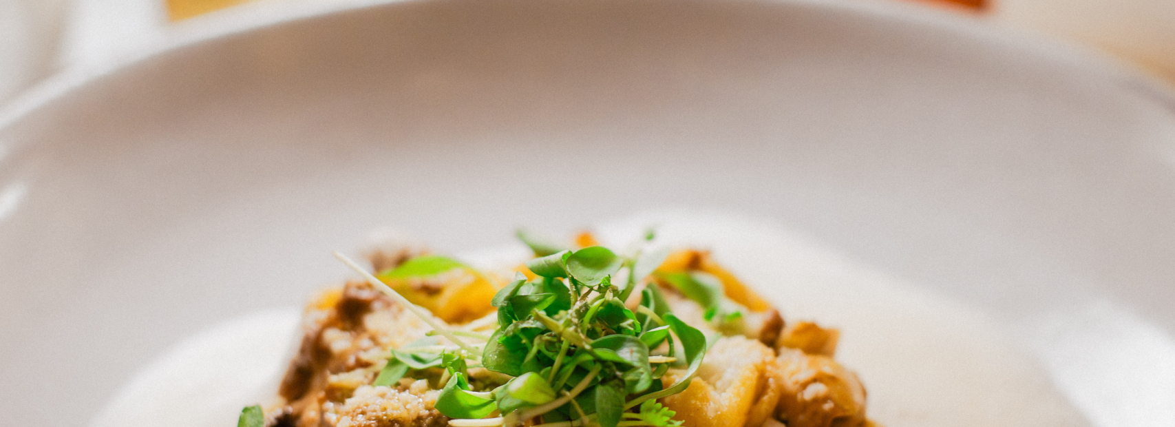 A plate of savory gourmet pasta garnished with microgreens at one of the finest Italian restaurants in Los Angeles.